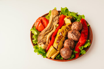 A vibrant display of marinated grilled vegetables and succulent meat, arranged on crisp, fresh lettuce