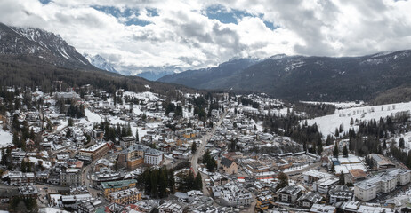 Aerial view of Cortina d'Ampezzo, Italy, with snow covered rooftops, alpine architecture, mountain...