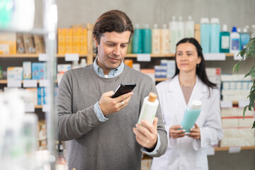 Man scans QR code on medicated shampoo label. Female pharmacist offers to choose the right shampoo