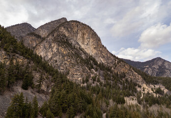 Majestic Mountain Range with Forested Slopes Under a Cloudy Sky