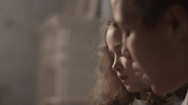 Young mother teaching daughter solfeggio music in room