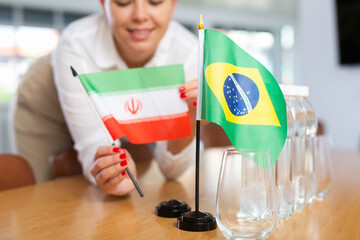 Little flag of Brazil on table with bottles of water and flag of Iran put next to it by positive...
