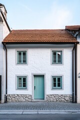 Obraz premium Nestled in a quaint European town, this enchanting historic house features a delightful light blue door, inviting all who pass by during the serene early morning hours