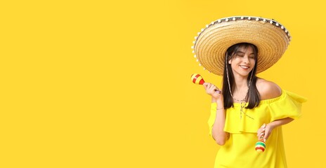 Young woman in sombrero playing maracas on yellow background with space for text