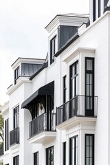 Obraz premium Stylish modern architecture showcases balconies and large windows on a white brick building in an urban setting, capturing elegance and sophistication during a cloudy day