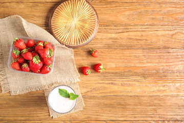 Glass of tasty strawberry smoothie on wooden background