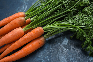 Fresh carrots with leaves on blue background