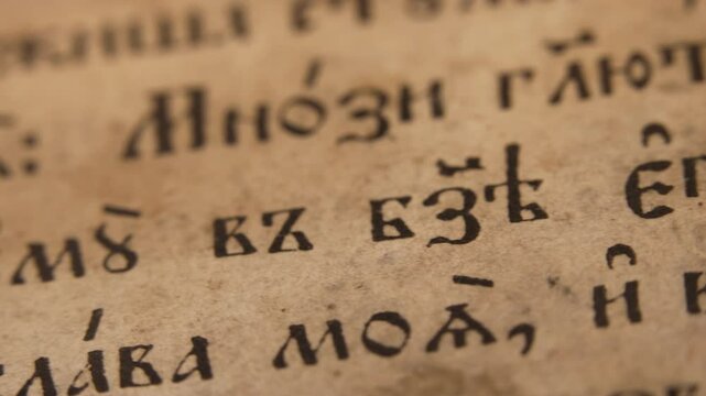 Slider footage Slavic Gospel, old Bible pages with candle wax, antique religious
