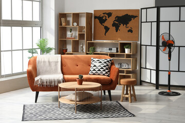 Interior of stylish living room with electric fan, sofa and table