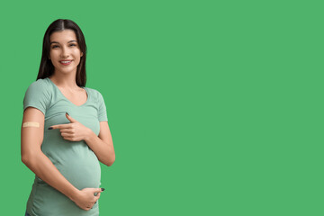 Young pregnant woman after vaccination on green background