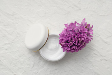 Jar of natural cream and hyacinth flower on light background