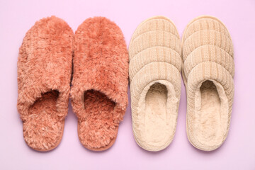 Two pairs of soft slippers on lilac background. Top view