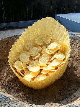 Naklejki Giant Cereal Bowl Filled with Cornflakes in Sandy Ground