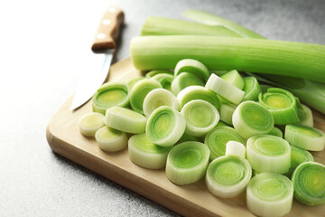 Chopped leeks and knife on grey table, closeup