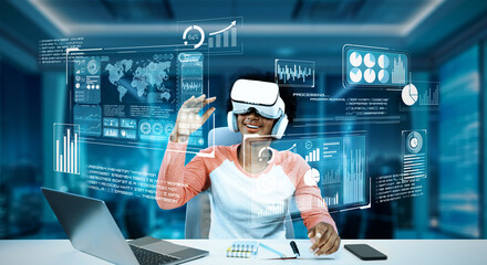 Girl using laptop and augmented glasses connecting metaverse while doing homework at table by using...