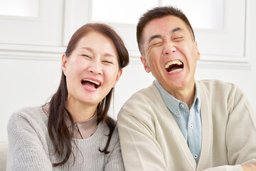 シニアの夫婦　笑顔　カメラ目線　ポートレート　リビング