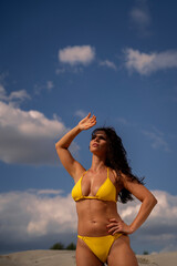 Attractive natural woman in yellow bikini posing , vertical image 