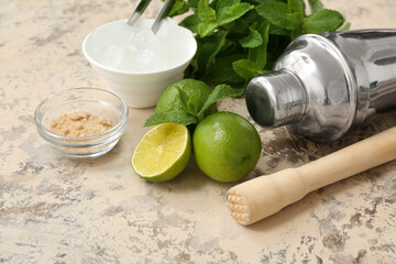 Wooden pestle, shaker and ingredients for preparing mojito on grunge background, closeup