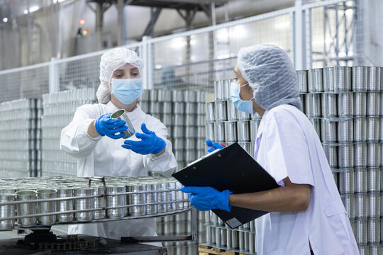 Quality control inspectors reviewing canned food production