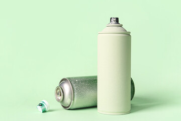 Spray paint cans on green background