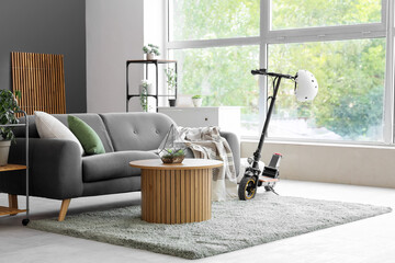 Interior of living room with electric scooter, sofa and table