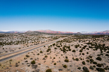 aerial view of desert landscape with red rock mountains in the background