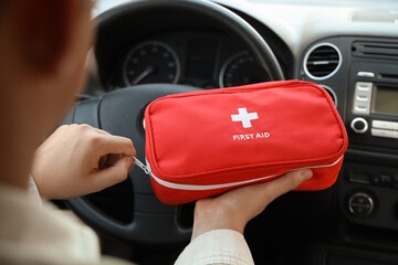 Male driver opening first aid kit in car, closeup