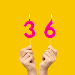 Birthday number 36 - Hands holding fuchsia colored candles