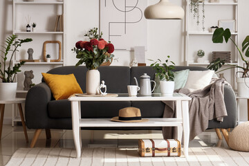 Cozy sofa and table with dahlia flowers in living room