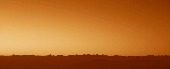 beautiful mountain range with golden blue yellow sunset sky. Sunset over mountain peaks. Silhouette of Caucasian mountains at the evening. Bakhmaro, Georgia. Caucasus region. horizon line.