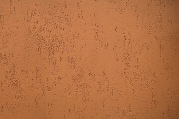 Full frame image of textured stucco in bright terracotta color. backdrop texture of brown red yellow orange plaster for 3d model, background, pattern, poster, collage, gift wrap, wallpaper