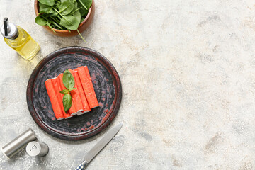 Plate with tasty crab sticks, basil and spinach leaves on white background © Pixel-Shot
