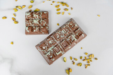 Handmade Belgian milk chocolate bar with pistachios and filled with ganache_top view.