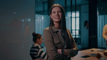 Businesswoman standing confidently in a modern office meeting room. Diverse team on a business meeting in a startup coworking open space office environment collaborating in the background. Corporate - Powered by Adobe
