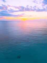 Aerial view of colorful sunrise over ocean in Punta Cana. Breathtaking scenery showcases sky painted with stunning hues, while gentle waves reflect morning light. Perfect postcard capturing tropical