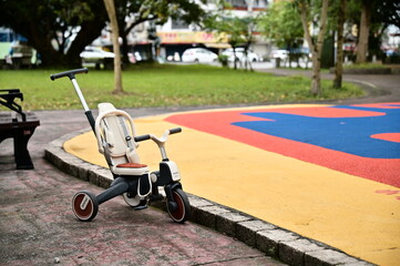 Taiwan - March 29, 2025: The photo captures a multifunctional tricycle beside a park play area, reflecting the lively and playful atmosphere of outdoor family recreation.