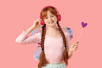 Cute redhead fairy in headphones on pink background