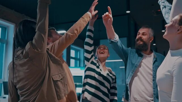 Business professionals stacking hands in support of collaboration, inclusion, and equality in the office. The workplace community huddles together for solidarity, cooperation, and team building.