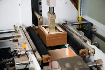 Innovative semi-automatic machine efficiently wraps rectangular boxes in a modern packaging facility