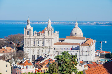 Obraz premium The view of Church of St. Vincent de from Castelo de S. Jorge is breathtaking, offering a stunning panorama of the historic rooftops, winding streets, and the Tagus River stretching into the horizon.