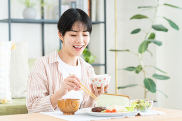 家で昼食を食べる若い女性