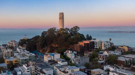 Coit Tower stands tall over San Francisco, California, USA, at sunset. The tower is a landmark and tourist destination, offering panoramic views of the city