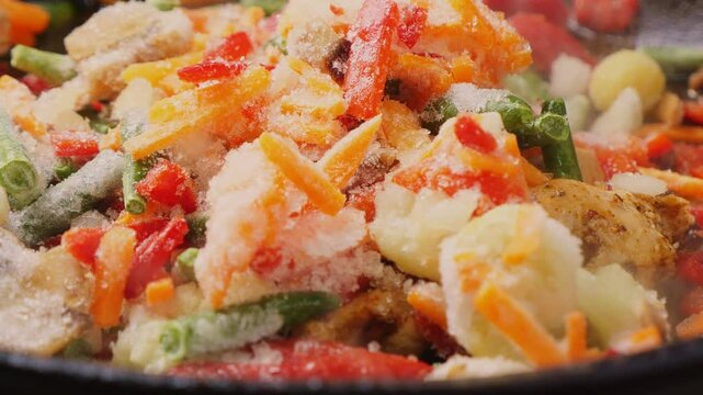 vegetables fried in a pan with oil in soy sauce with chicken fillet. Medium plan.
