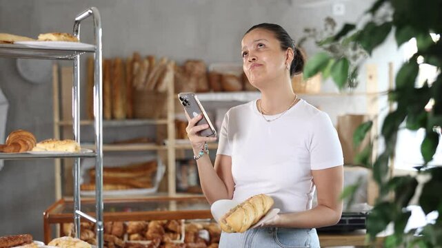Positive female customer scans bocadillo with her phone counting calories at the bakery. High quality 4k footage