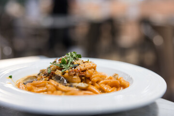 Delicious pasta on the plate at restaurant table.