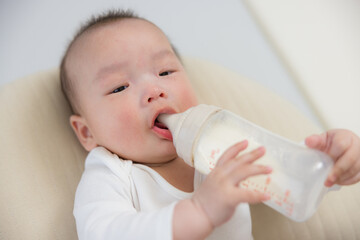 Adorable baby drinking milk from bottle