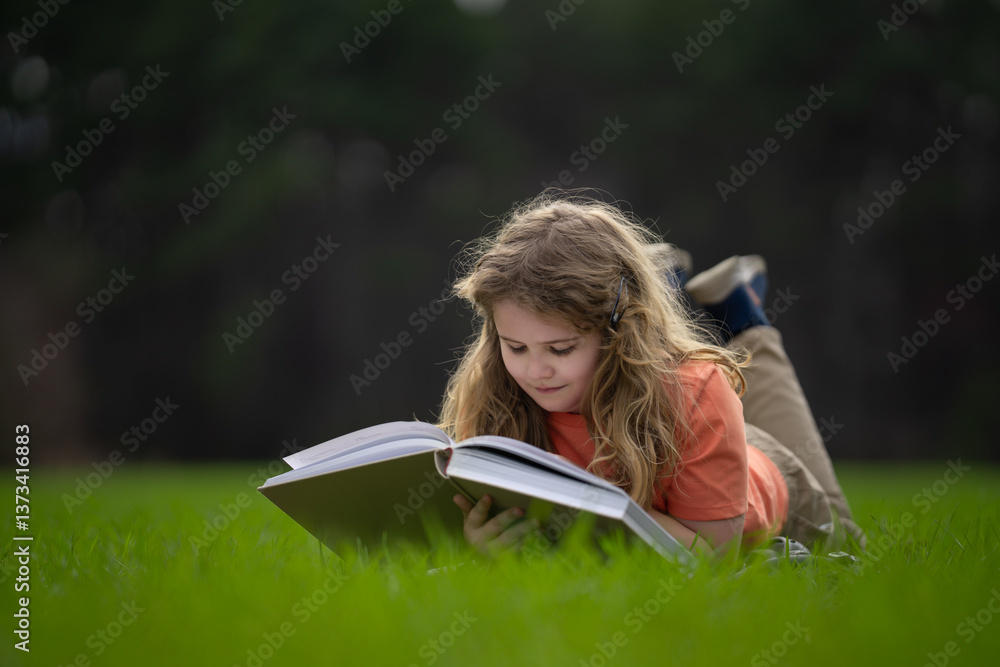 Poster child reading a book in the grass. kid enjoying a book story outdoors. child studying with book in t