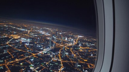 Nighttime aerial view of vibrant cityscape from airplane window in motion - Powered by Adobe