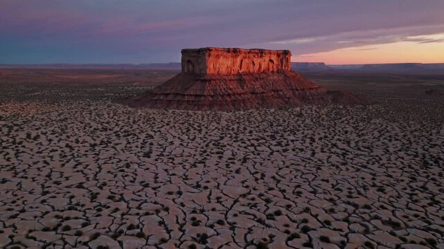 Mesmerizing aerial view of desert mesa at sunset with dramatic sky and cracked earth