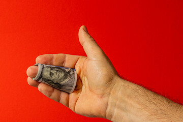 Dollar bill held in hand against a red background